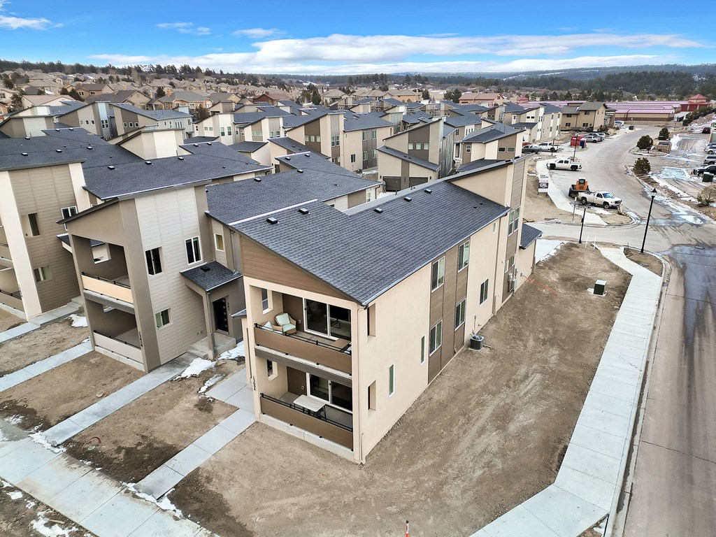 A view of a housing development with apartment buildings and a road.