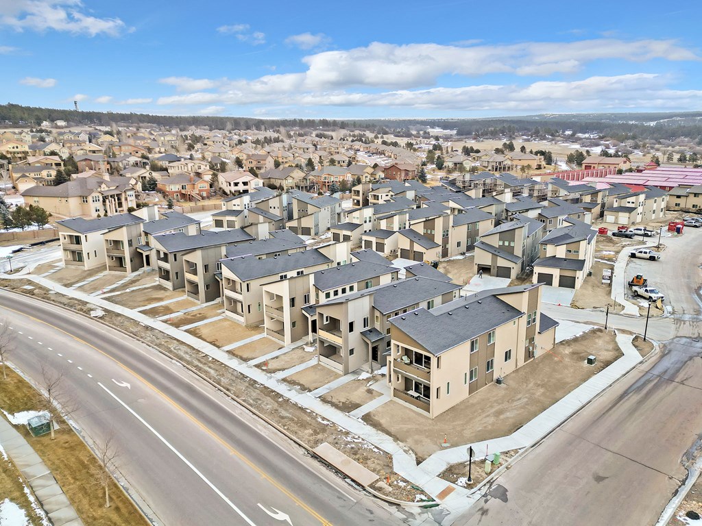 A road with a median strip and apartment buildings on either side.