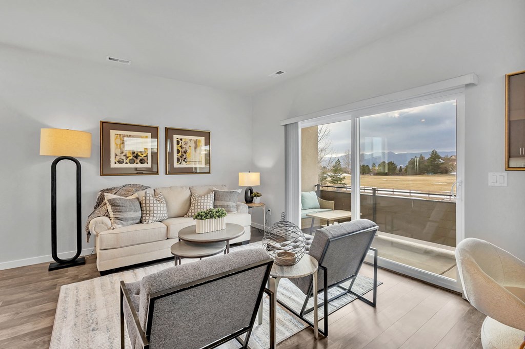 A living room with a couch, chair, and a table with a vase on it.