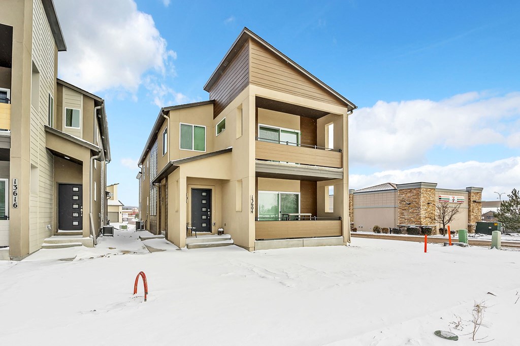 A row of houses with snow on the ground.