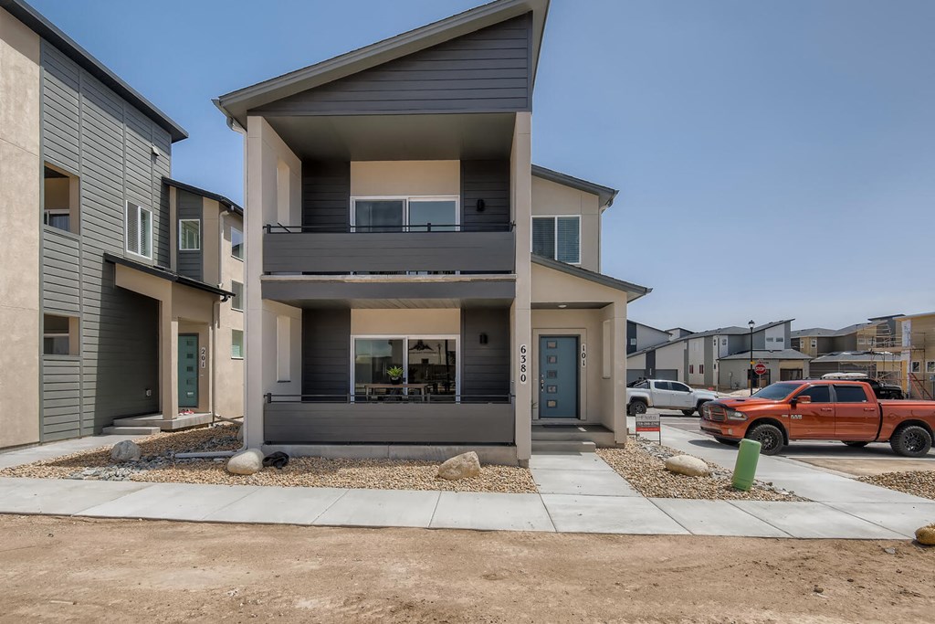 the front of a house with a driveway and a red truck
