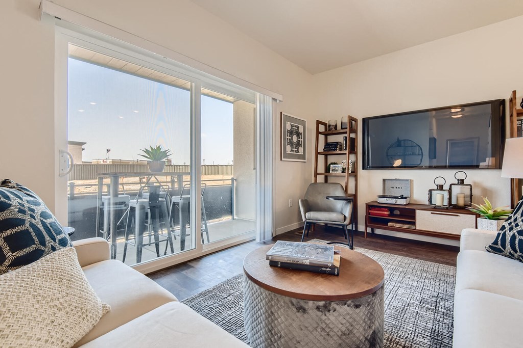 a living room with a couch and a tv and a balcony