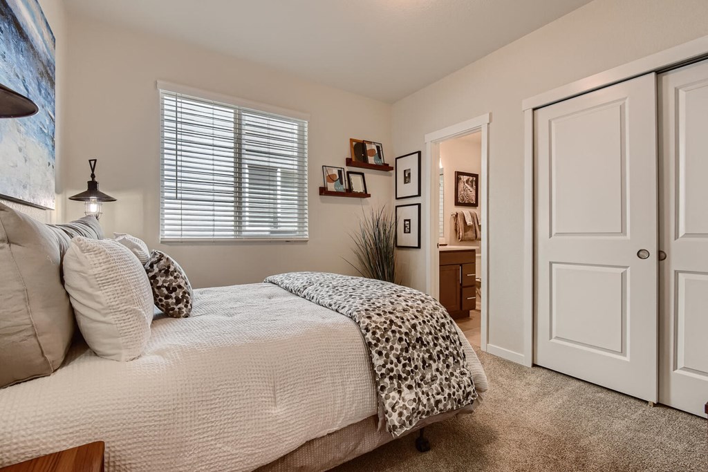 a bedroom with a bed and a door to a bathroom