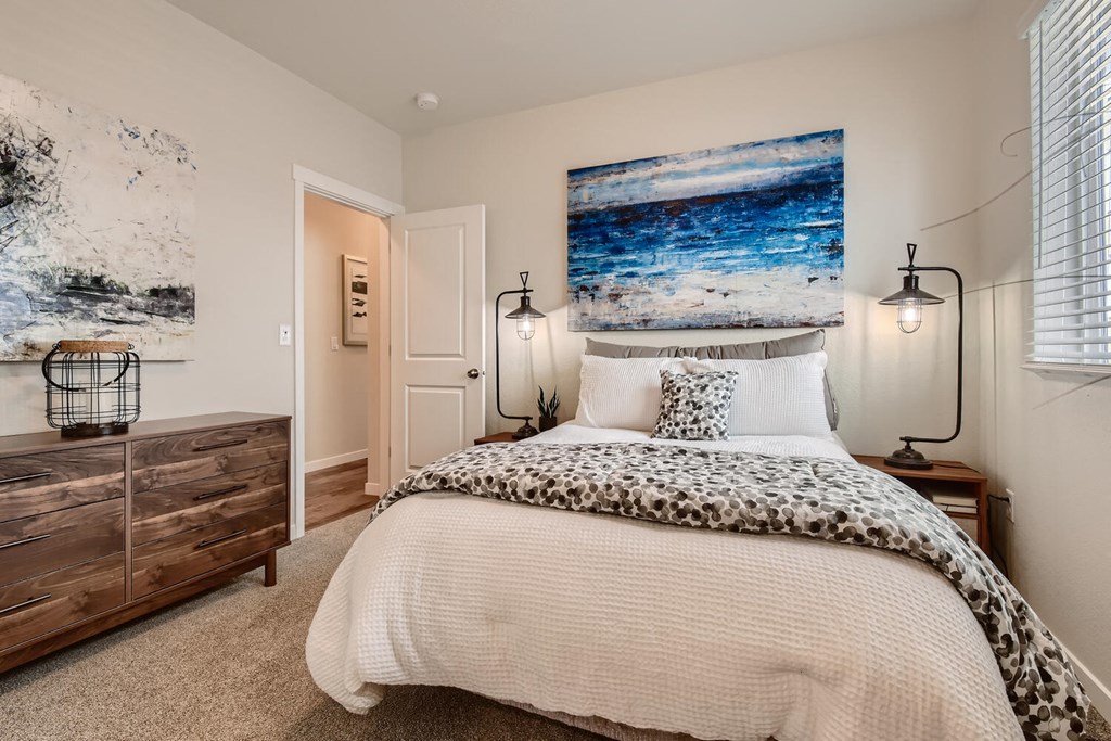 a bedroom with a bed and a painting on the wall