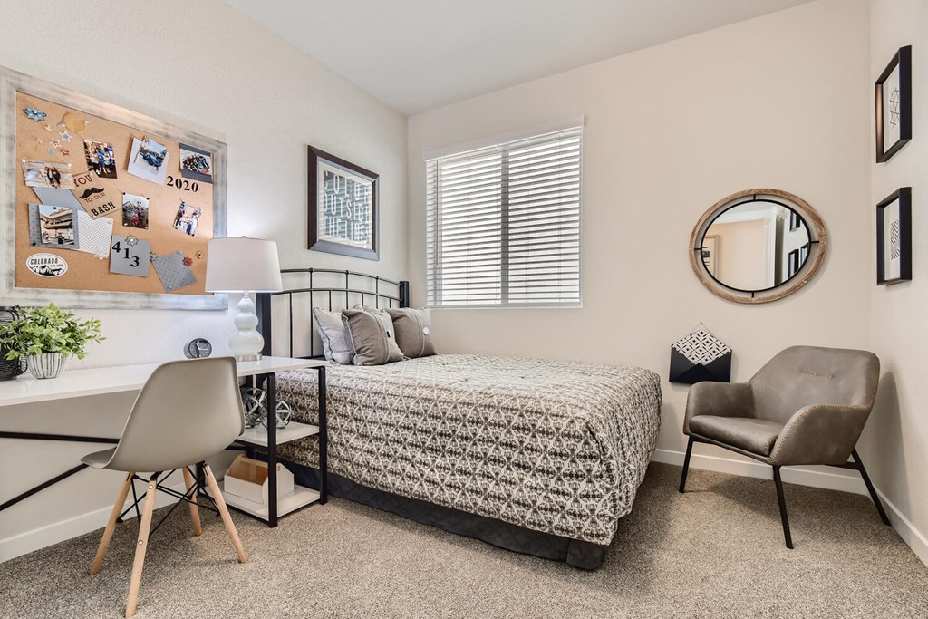 a bedroom with a bed and a desk with a chair