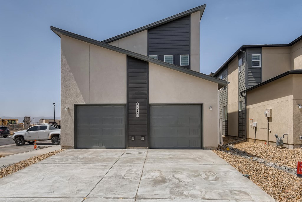 the front of a building with two garage doors