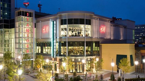 A H&M store is lit up at night.