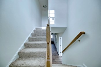 entry foyer with hardwood floors and white door wood rails leading upstairs - Photo Gallery 23