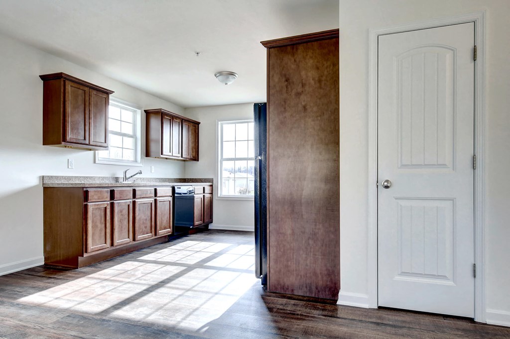 natural wood cabinets with laminate countertops and black appliances