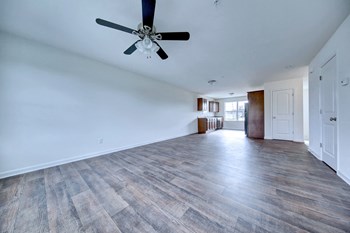 living room with hardwood floors and ceiling fan stairs leading up to the third level - Photo Gallery 3