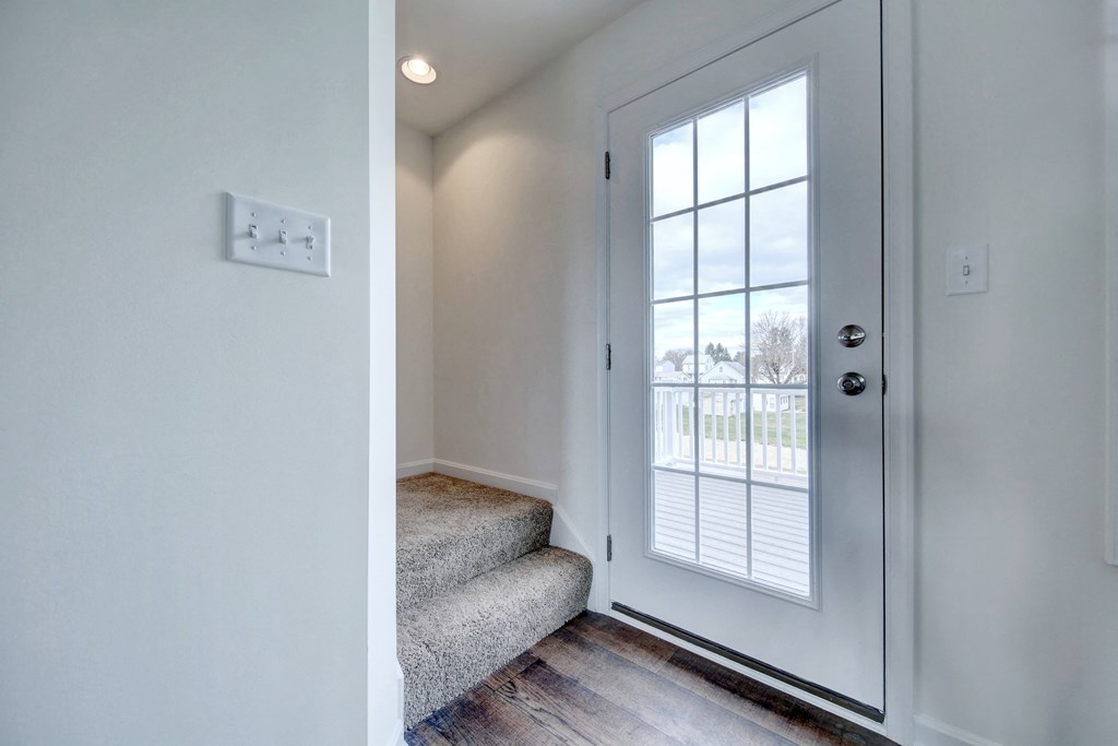 stairwell with grey carpet hardwood floors hallway leading to den