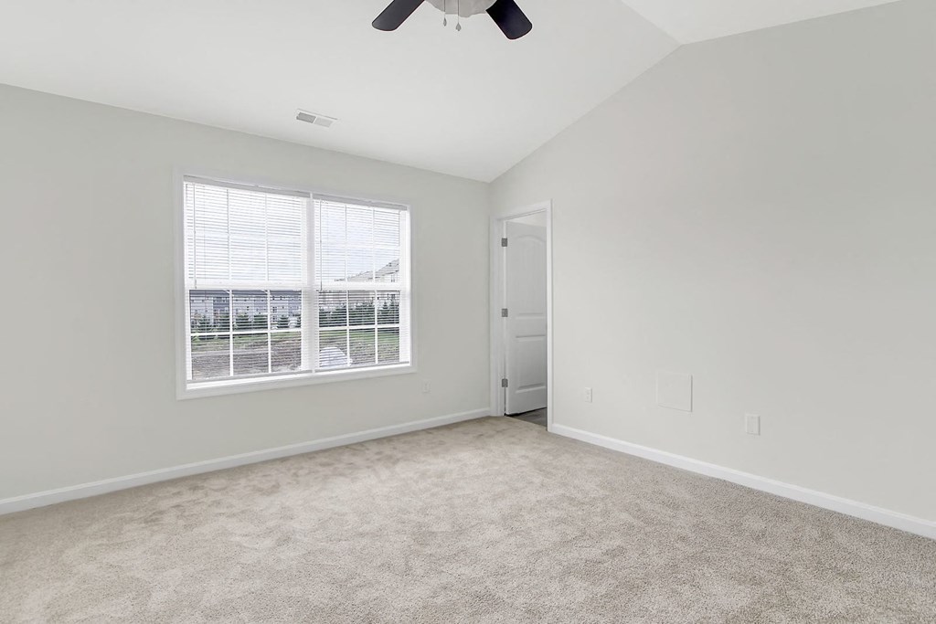 Empty living room with a window and a ceiling fan