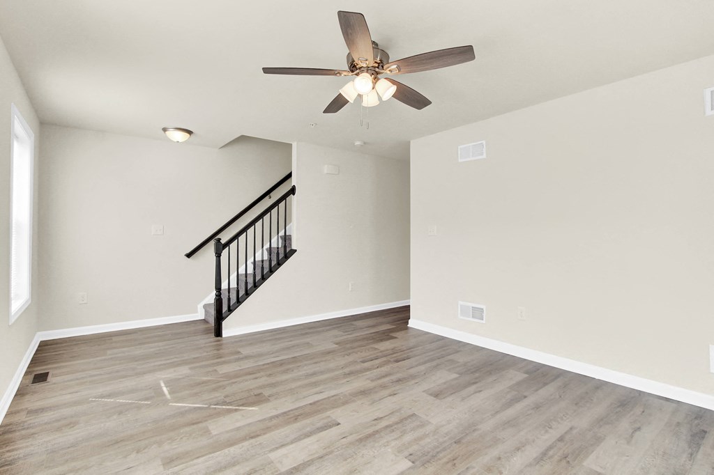 living room with hardwood floors and ceiling fan stairs leading up to the third level  at Franklin Square Apartments/Townhomes, Pennsylvania