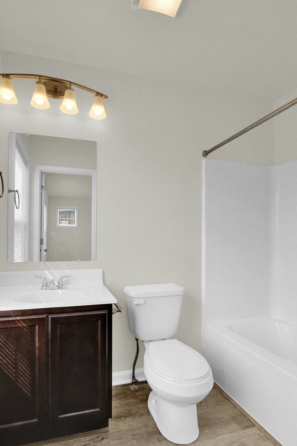 bathroom with hardwood floors and ceramic toilet and sink