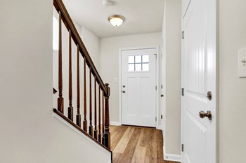 entry foyer with hardwood floors and white door wood rails leading upstairs - Photo Gallery 2