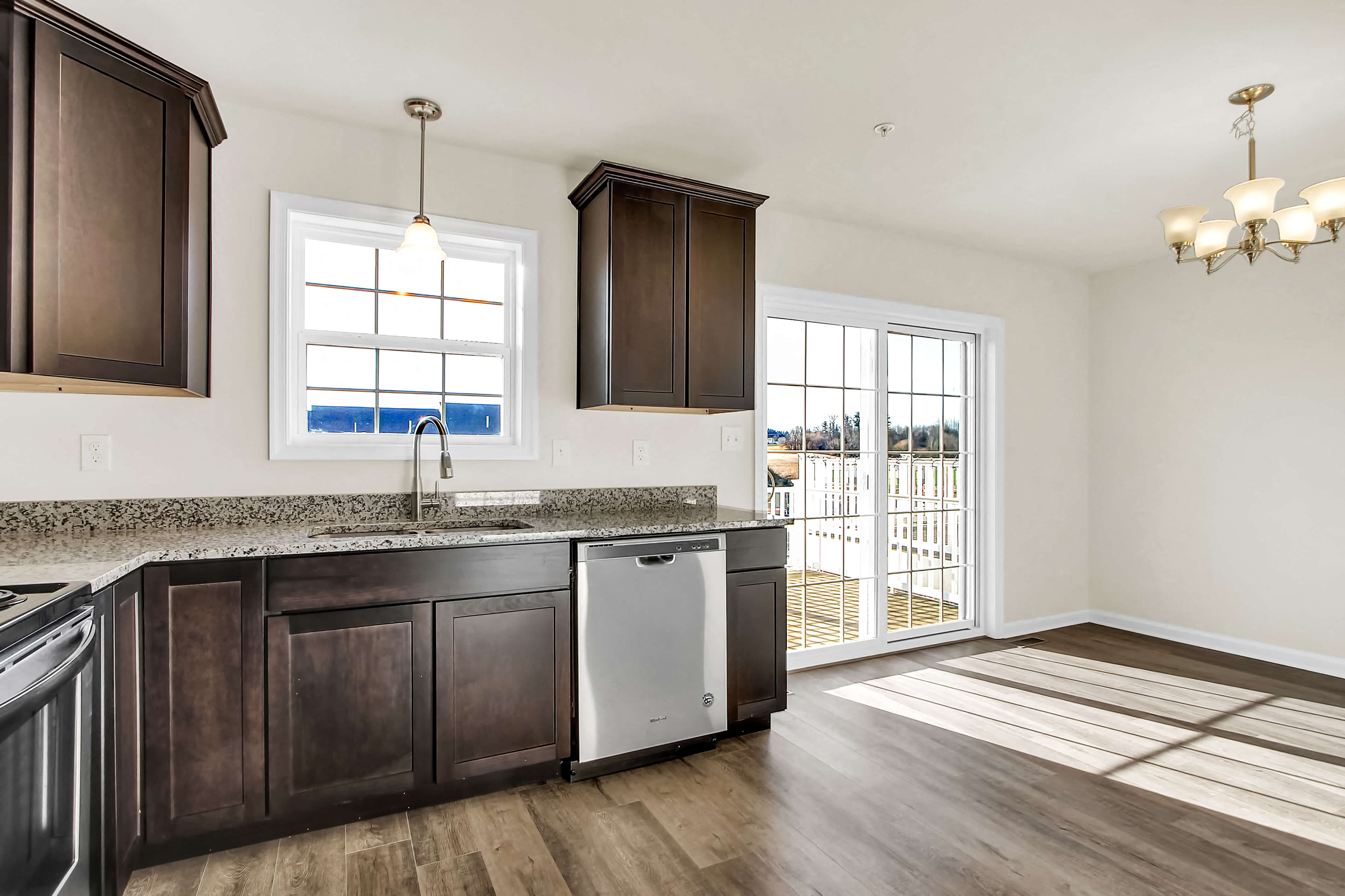 a kitchen with wooden cabinets and a door to a balcony