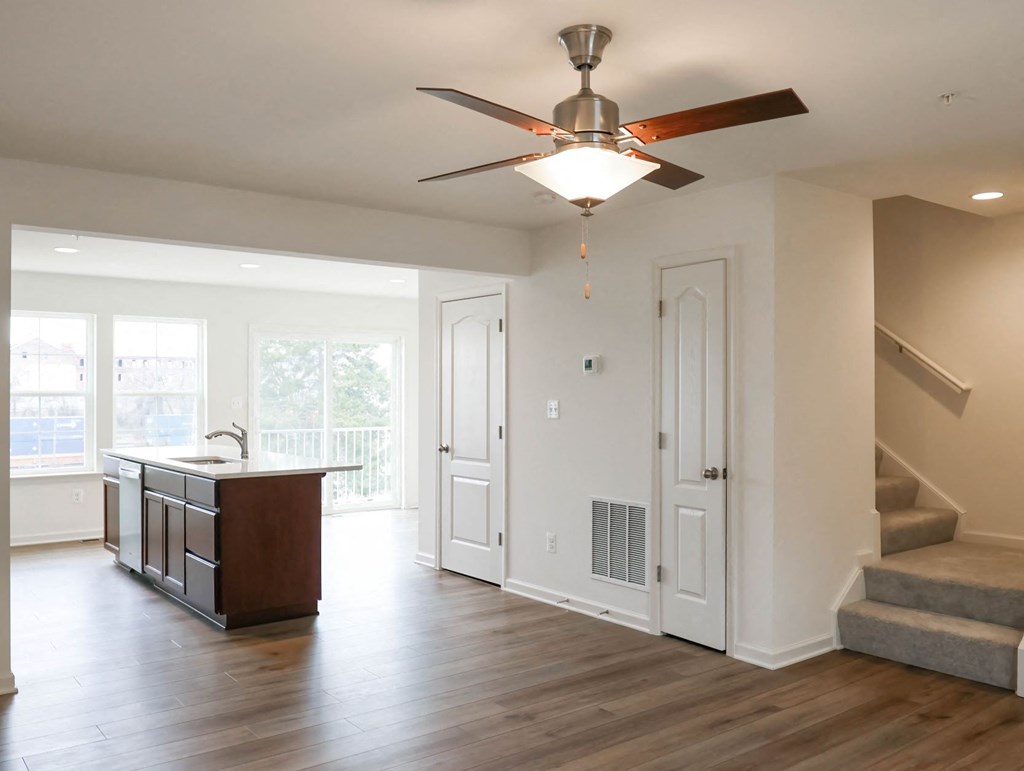 an empty living room with a ceiling fan