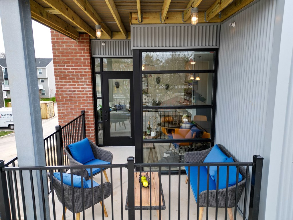 a patio with chairs and a table and sliding glass doors at Franklin Square Apartments/Townhomes, New Freedom, PA