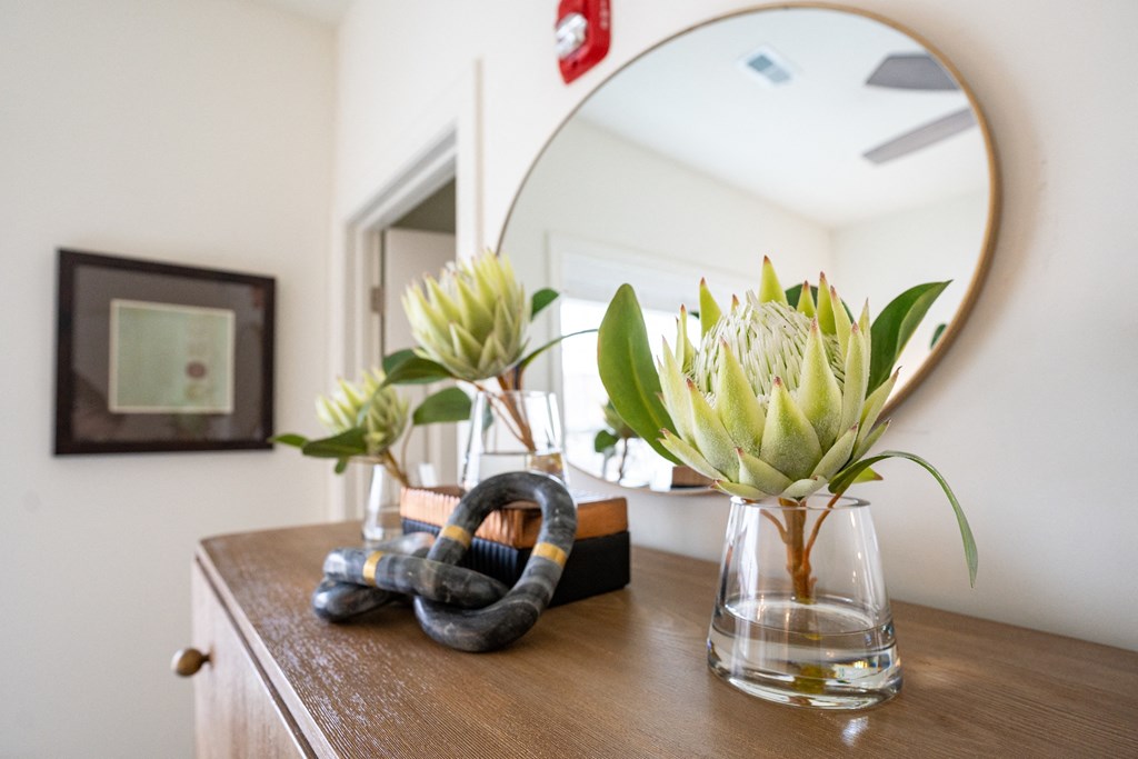 a bathroom with a mirror and flowers in a vase on a counter at Franklin Square Apartments/Townhomes, Pennsylvania