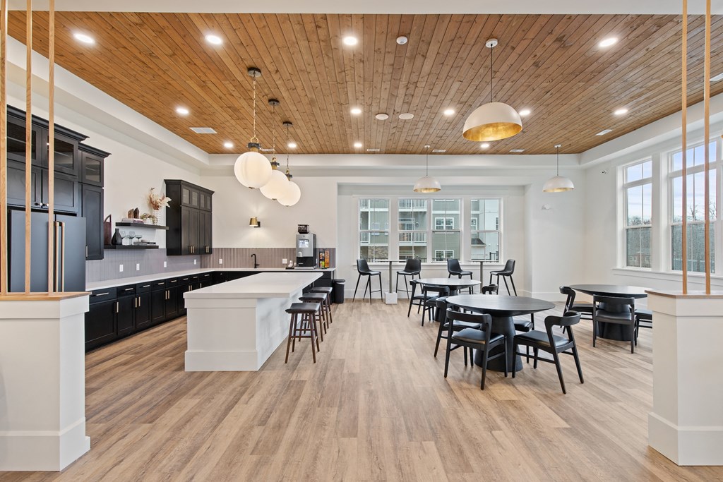 Open kitchen and dining area with tables and chairs and a large windowat Hadley Place Apartments, Pennsylvania