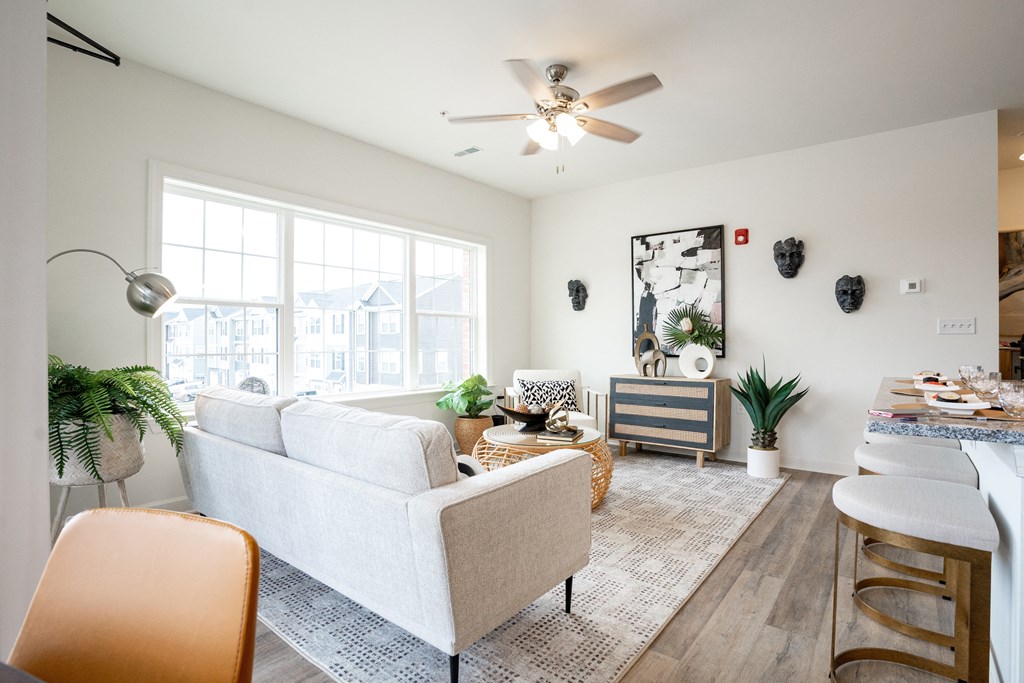 a living room with a ceiling fan and a large window at Franklin Square Apartments/Townhomes, New Freedom, PA