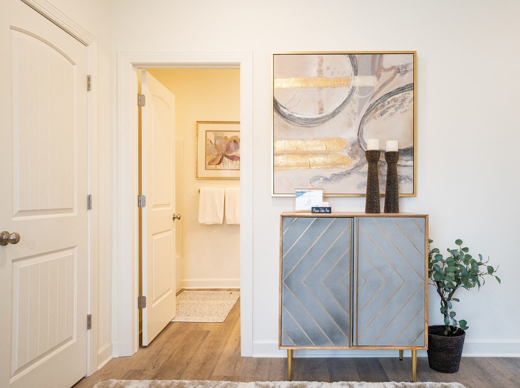 a hallway with a dresser and paintings on the wall  at Franklin Square Apartments/Townhomes, Pennsylvania