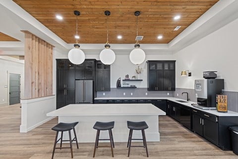 a kitchen with a large white island and black cabinets