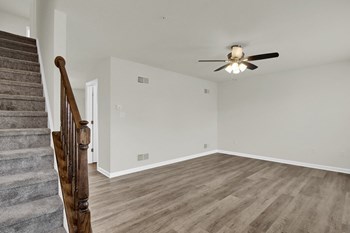 living room with hardwood floors and ceiling fan stairs leading up to the third level - Photo Gallery 4