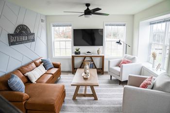 a living room with white walls and a brown leather couch