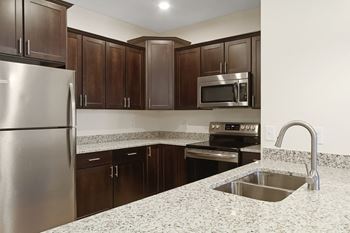 a kitchen with granite counter tops and stainless steel appliances at Hadley Place Apartments, Enola
