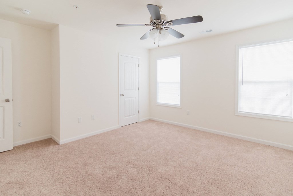 bedroom with grey carpet and ceiling fan natural light