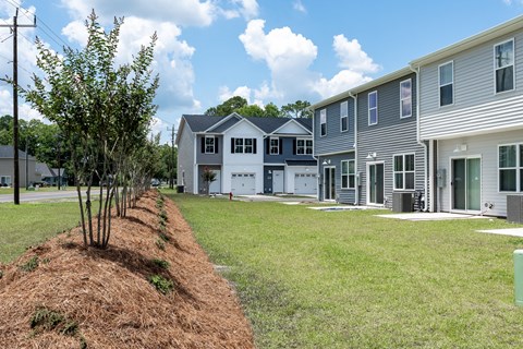 a row of townhouses with a grassy yard in front  at Beckington, Leland, North Carolina
