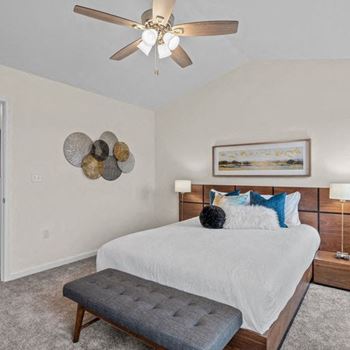 a bedroom with a large bed and a ceiling fan