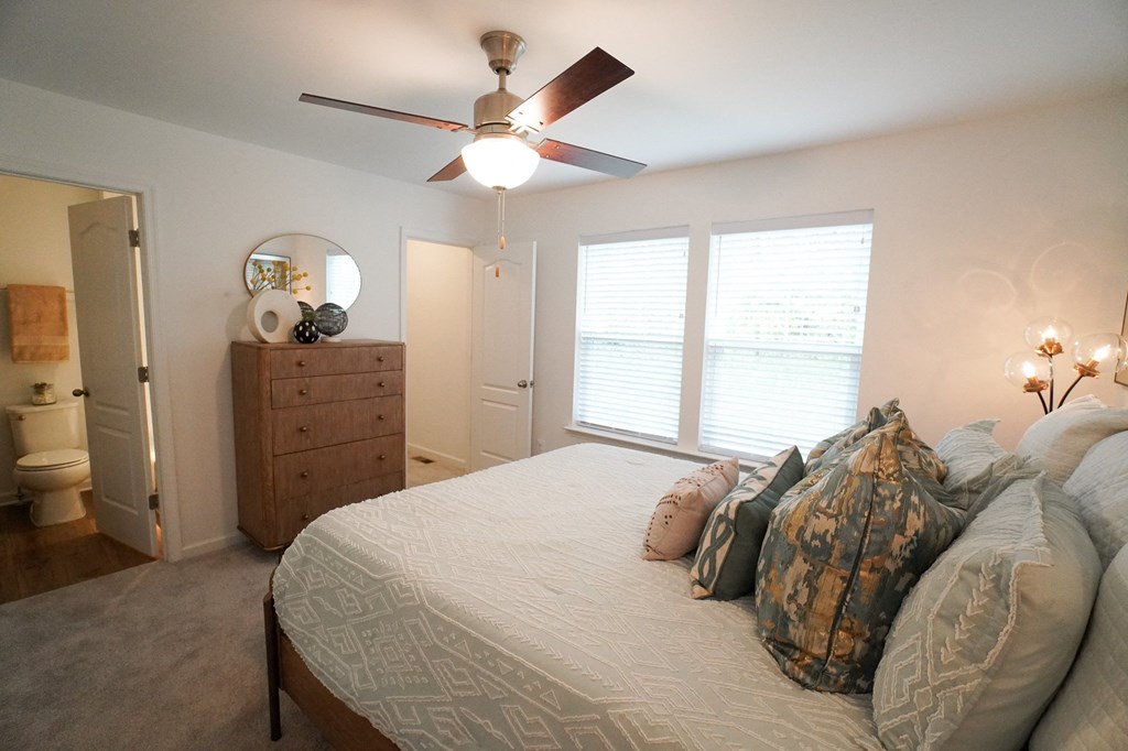 a bedroom with a large bed and a ceiling fan