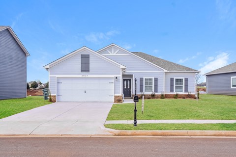 a white house with a driveway and a parking meter