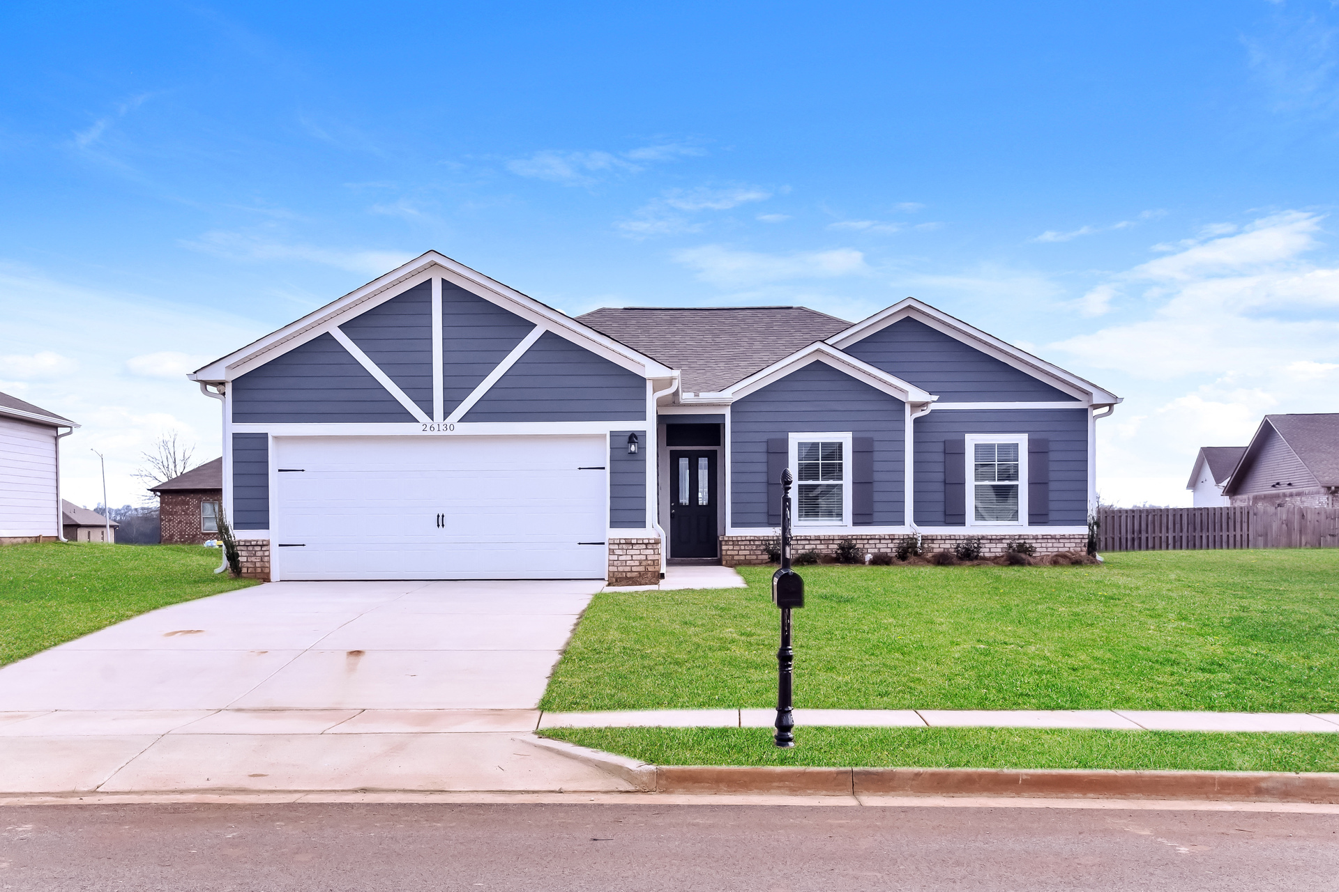 a blue house with a white garage door on a lawn