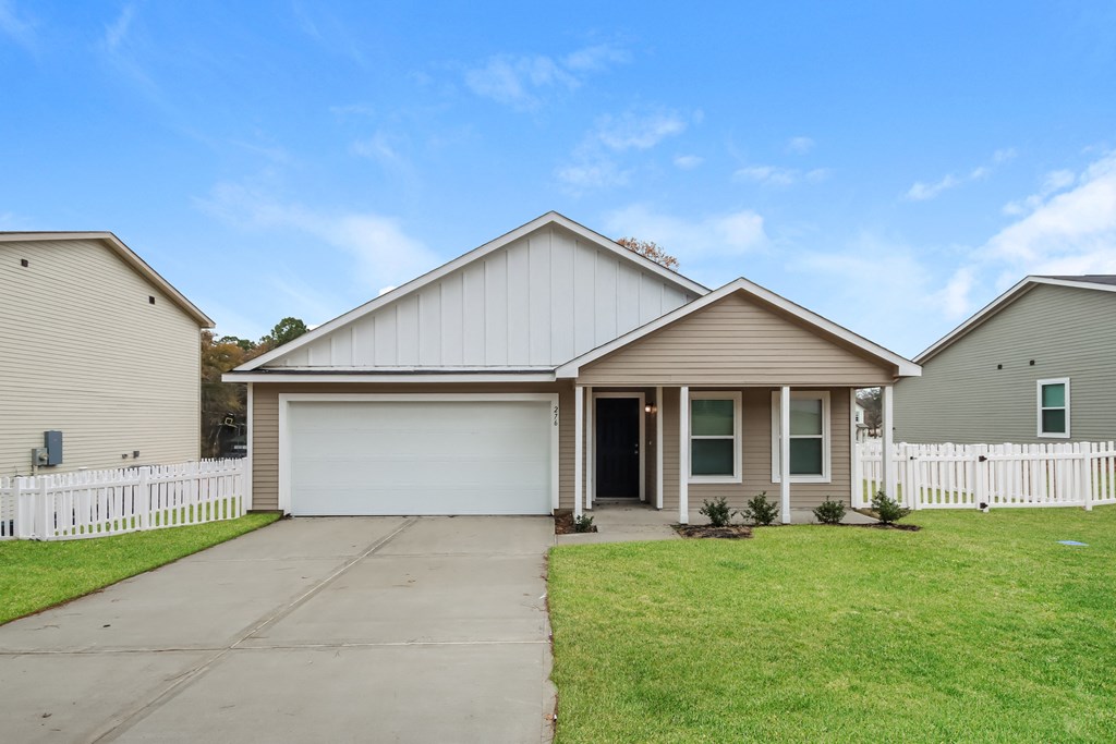 a white house with a white fence and a driveway