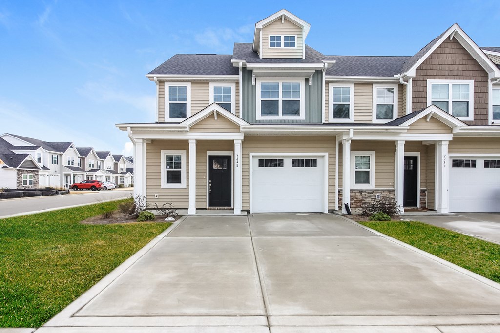 a beige house with a driveway in front of it
