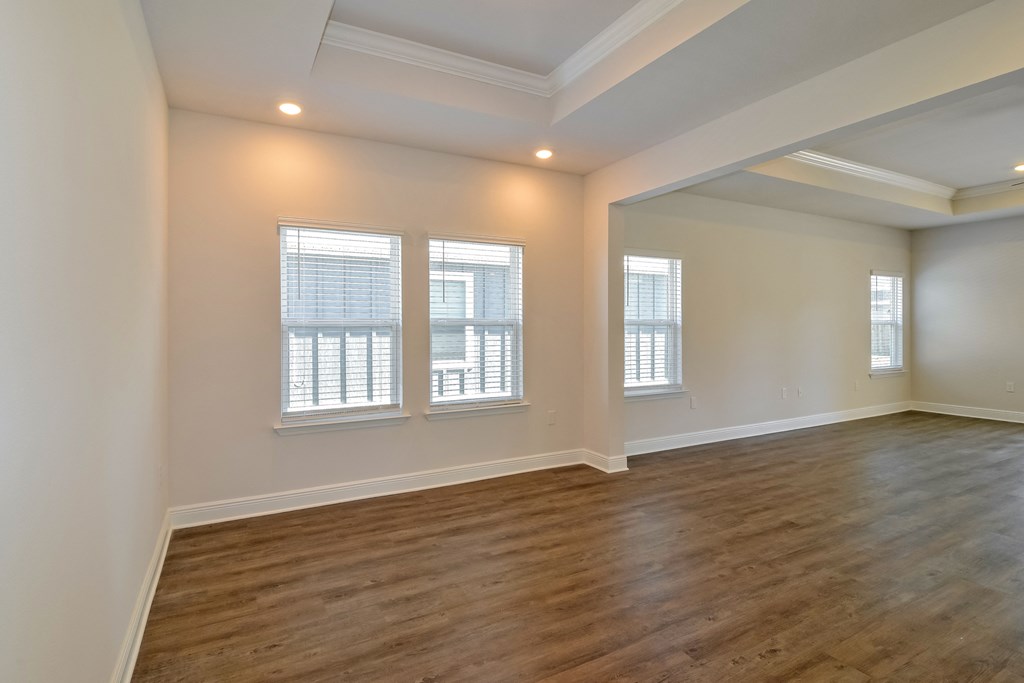 an empty living room with wood floors and windows