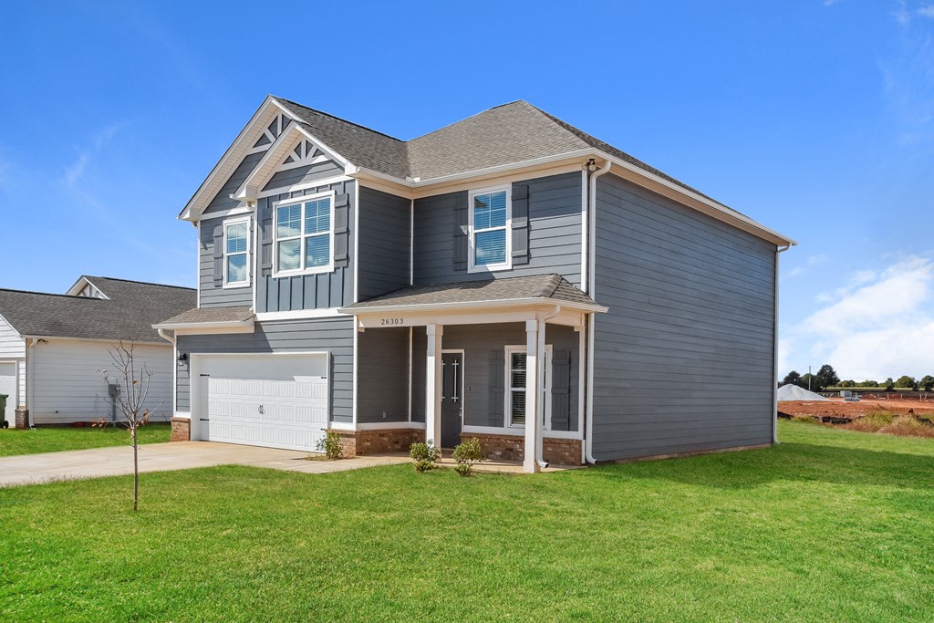 a blue house with a garage and a green lawn