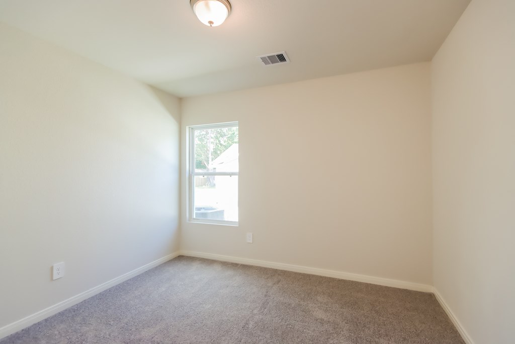 an empty room with white walls and a window