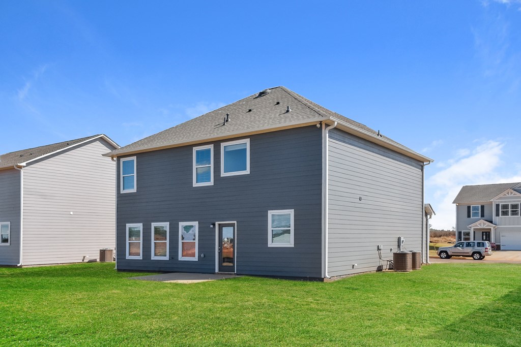 a blue house with a gray roof and a green yard