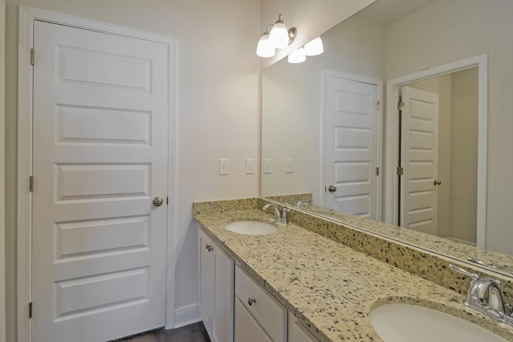 an empty bathroom with two sinks and a large mirror