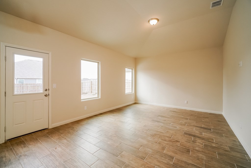 an empty living room with wood floors and a white door