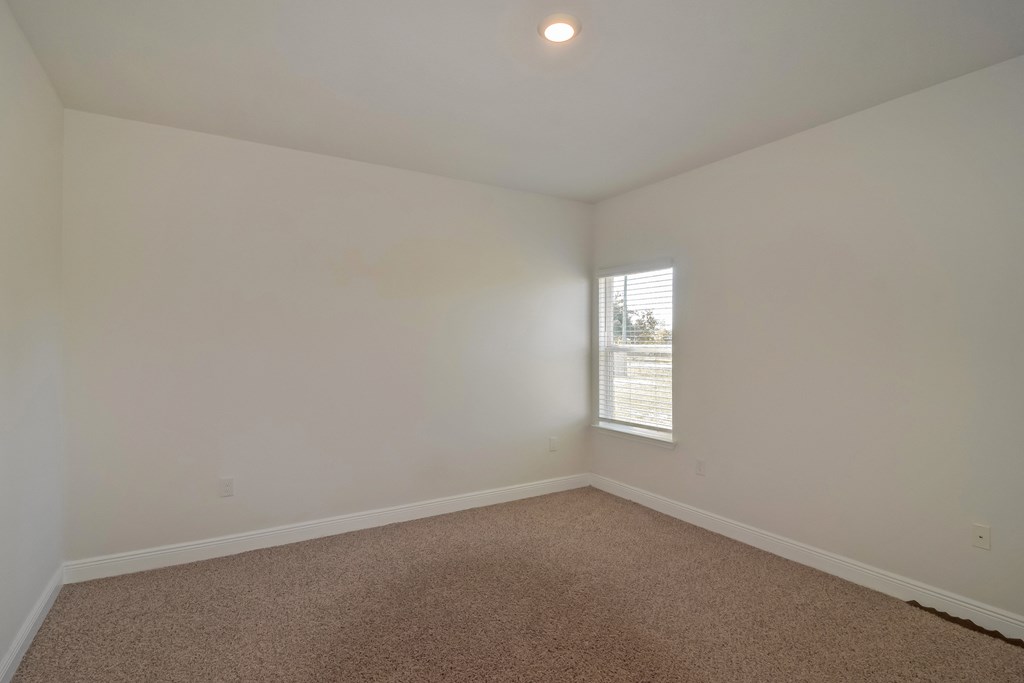 an empty room with white walls and a window