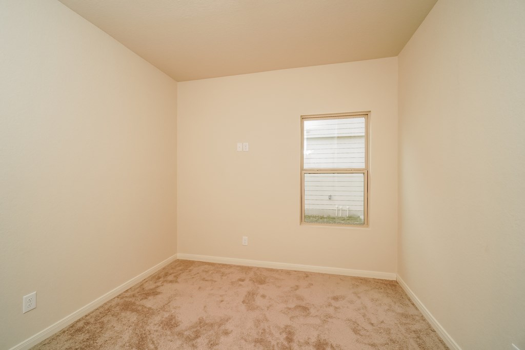 an empty room with carpet and a window