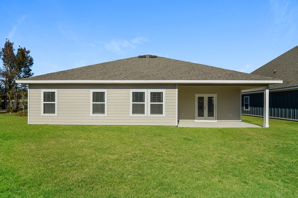 a beige house with a lawn in front of it
