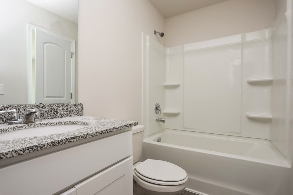 a bathroom with a toilet and a tub and a sink