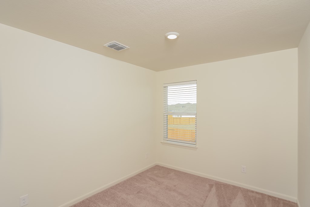 an empty room with a window and a carpet