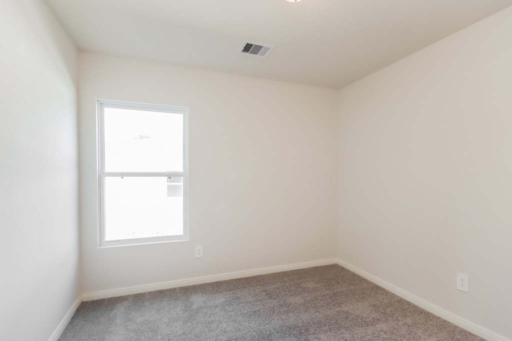 an empty room with a window and a carpet